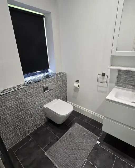 Bathroom with a wall-hung WC, tiled splashback and dark floor tiles