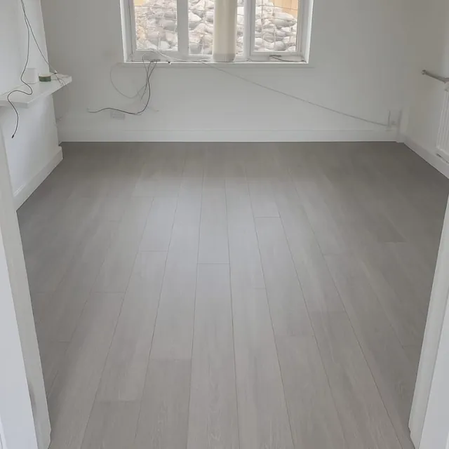 Grey laminate flooring laid across a finished room